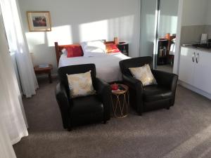 a bedroom with two chairs and a bed at STUDIO ECHUNGA Adelaide Hills in Echunga
