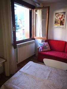 - une chambre avec un canapé rouge et une fenêtre dans l'établissement Apartamento Formigal - Sallent de Gállego, à Sallent de Gállego