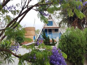 uma casa azul com uma cerca branca e flores roxas em Chalé Ribeira Doce em Presidente Epitácio