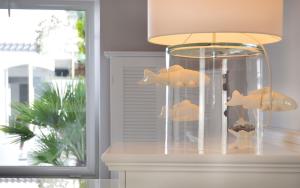 a lamp with two goldfish in a glass container at Hotel Cala Moresca in Bacoli