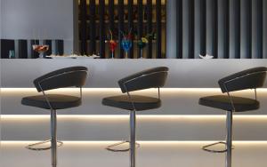four chairs sitting in front of a white table at Hotel Cala Moresca in Bacoli