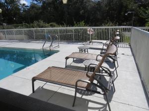 een patio met tafels en stoelen naast een zwembad bij Holiday Inn Express - Spring Hill FLORIDA, an IHG Hotel in Spring Hill