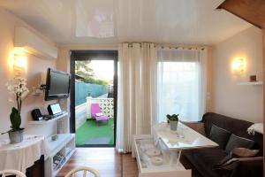 a living room with a couch and a table and a television at Pavillon de Diane in Prades
