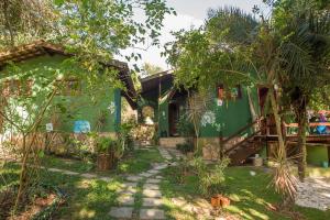 une maison verte avec un sentier devant elle dans l'établissement Recanto dos Passaros, à Praia do Forte