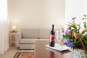 una bottiglia di vino seduta su un tavolo con un bicchiere di Masseria 30 Mogge a Muro Leccese