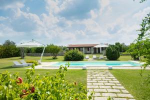 a villa with a swimming pool and a house at Masseria 30 Mogge in Muro Leccese