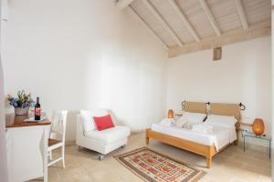 ein Wohnzimmer mit einem Sofa und einem Stuhl in der Unterkunft Masseria 30 Mogge in Muro Leccese