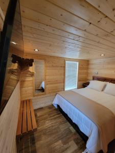 ein Schlafzimmer mit einem Bett in einer Holzhütte in der Unterkunft 079 Tiny Home nr Grand Canyon South Rim Sleeps 8 in Valle