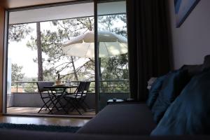 um quarto com uma cama, uma mesa e uma grande janela em Barca House - Nature - Golf - Pool & Beach em Esposende