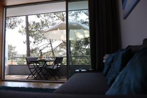 a bedroom with a bed and a table and a large window at Barca House - Nature - Golf - Pool & Beach in Esposende