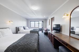 a hotel room with two beds and a television at Adelaide Inn in Adelaide
