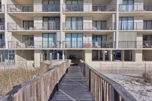 a boardwalk leading to a building on the beach at Lei Lani Tower by Meyer Vacation Rentals in Orange Beach