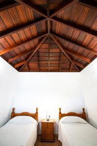 two beds in a room with a wooden ceiling at Casas los Alisios II in Los Quemados