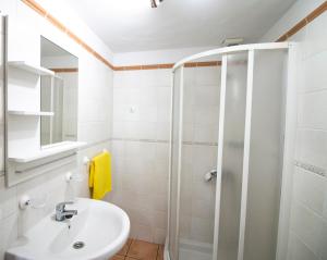 La salle de bains blanche est pourvue d'une douche et d'un lavabo. dans l'établissement Casas los Alisios II, à Los Quemados