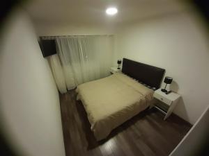 1 dormitorio pequeño con 1 cama y 2 mesitas de noche en Departamento Centrico en Rosario