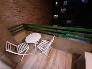 2 sillas y una mesa en una terraza de madera en Departamento Centrico en Rosario