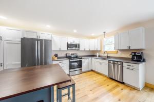 uma cozinha com armários brancos e electrodomésticos de aço inoxidável em Lakeview Heights em Greenville