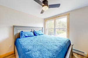 een slaapkamer met een blauw bed en een plafondventilator bij Lakeview Heights in Greenville
