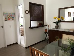 una sala da pranzo con tavolo in vetro e specchio di Flat Golden Coast a Rio de Janeiro Altre 16 foto