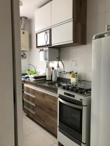 a kitchen with a stove and a refrigerator at Flat Golden Coast in Rio de Janeiro