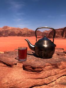 a tea pot and a cup of tea on a rock at Milky Way Bedouin Camp in Wadi Rum