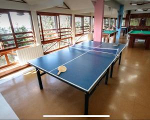 2 mesas de ping pong en una habitación con ventanas en Valor inacreditável para Ano Novo com vista e perto de tudo, en Gramado