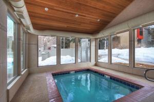 a swimming pool in a house with windows at 1100 Flying Dutchman condo in Keystone