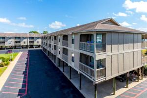 an apartment building with balconies and a parking lot at Casa Del Marina in Orange Beach