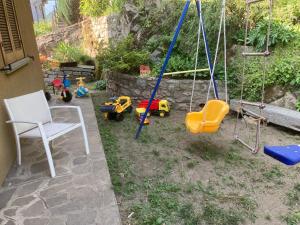 un'altalena e dei giocattoli in un cortile di Reginaldo's home Bed&Breakfast a Nesso