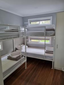 a room with three bunk beds and a window at Gulgong Tourist Park in Gulgong