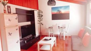 uma cozinha e sala de jantar com uma mesa e um frigorífico em Apartamento Sol y MAR em Morro del Jable