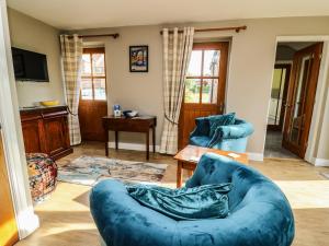 a living room with a blue couch and chairs at Decca Cottage Nidd Grange in York