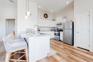 a kitchen with white cabinets and a stainless steel refrigerator at Sunrise Retreat in Rockport