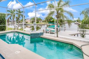 einen Pool mit Blick auf das Wasser und die Palmen in der Unterkunft Galleon's Treasure in Marco Island