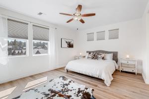a white bedroom with a bed and a ceiling fan at Wheeler Place in Flagstaff