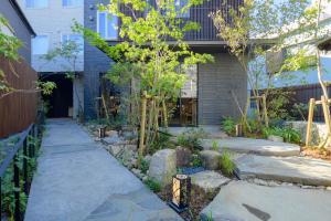 a garden with rocks and trees in front of a house at Tosei Hotel Cocone Kamakura in Kamakura