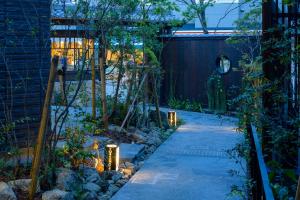 Tosei Hotel Cocone Kamakura في كاماكورا: حديقة فيها صخور وانوار بالليل