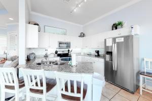 a kitchen with a stainless steel refrigerator and white cabinets at Crystal Cove 2223 in Destin