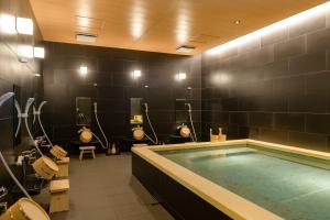 a large bathroom with a swimming pool and toilets at Tosei Hotel Cocone Kamakura in Kamakura