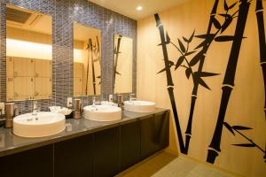 a bathroom with two sinks and a large mirror at Tosei Hotel Cocone Kamakura in Kamakura