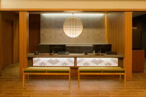 a desk with two benches in a room at Tosei Hotel Cocone Kamakura in Kamakura