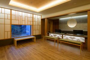 a waiting room with benches and a large window at Tosei Hotel Cocone Kamakura in Kamakura