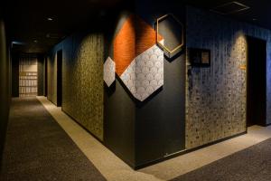 a hallway with a wall with tiles on it at Tosei Hotel Cocone Kamakura in Kamakura