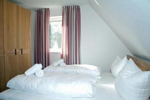 a bedroom with two pillows on a bed with a window at Dünenresidenz Glowe - Haus Marie in Glowe