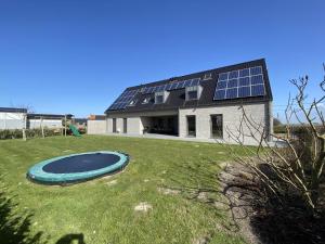 ein Haus mit Sonnenkollektoren auf einem Hof in der Unterkunft Coq au lit in De Haan
