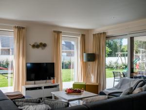 ein Wohnzimmer mit Sofa und Fernseher in der Unterkunft Coq au lit in De Haan
