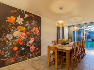 a dining room with a large painting of flowers on the wall at By Romme in Diessen