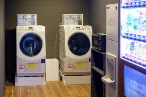 two washing machines sitting next to each other in a room at Tosei Hotel Cocone Kamakura in Kamakura