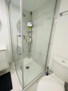 een douche met een glazen deur in de badkamer bij MT house in Mississauga