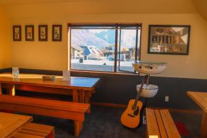 a room with a table, chairs, and a window at Adventure Queenstown Hostel in Queenstown